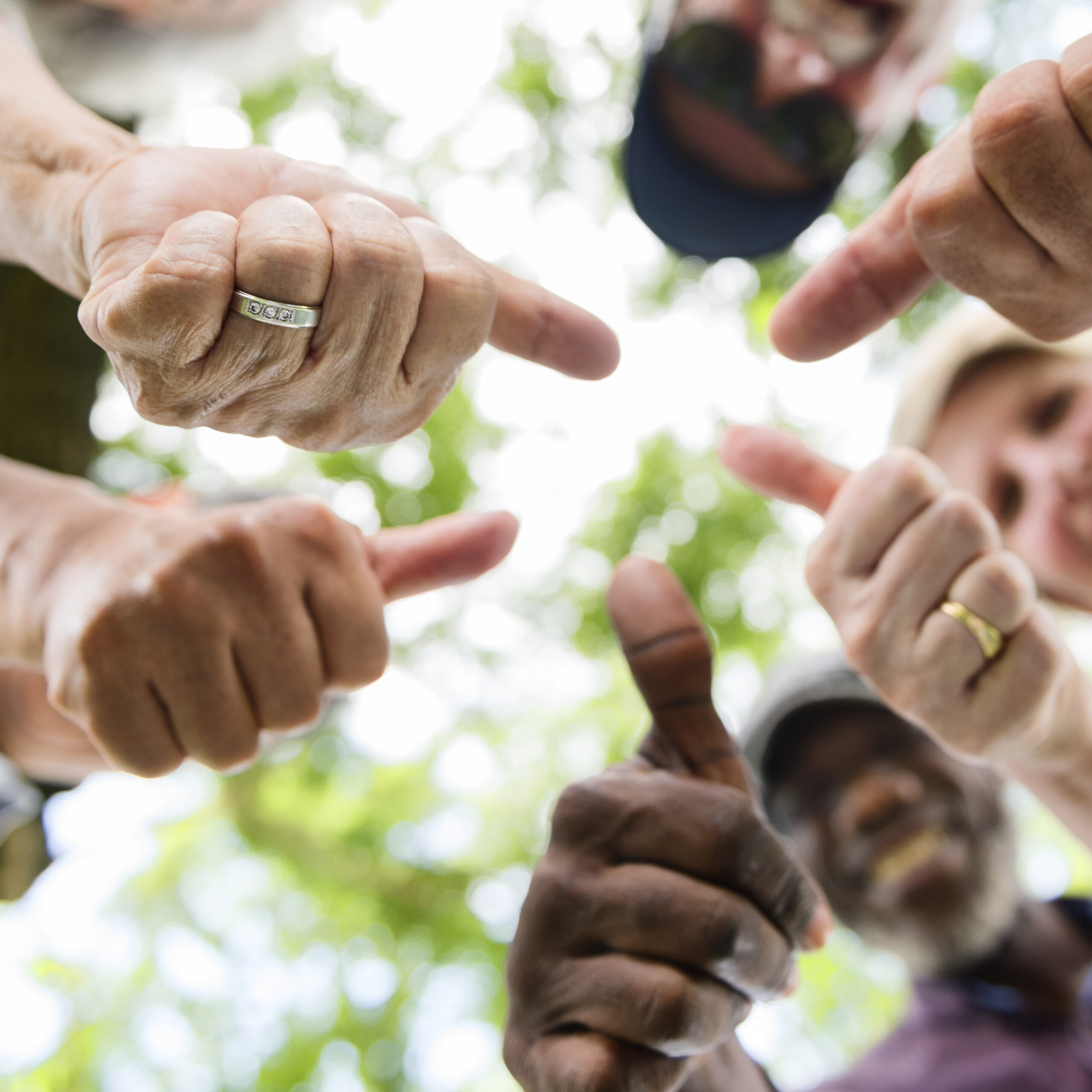 Group of older adults out of focus giving thumbs up to the camera