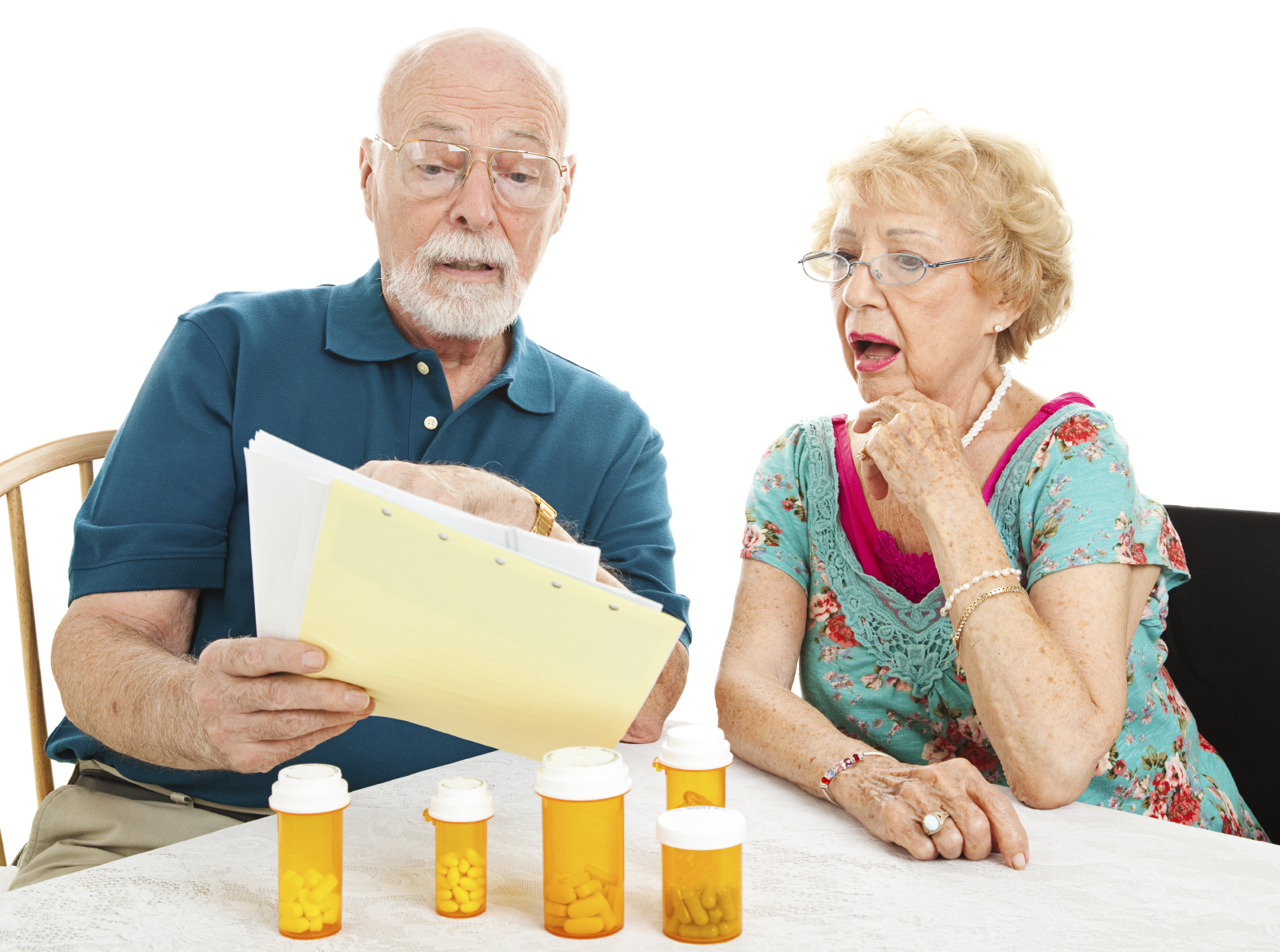 Two older adults with pill bottles looking at medical bills