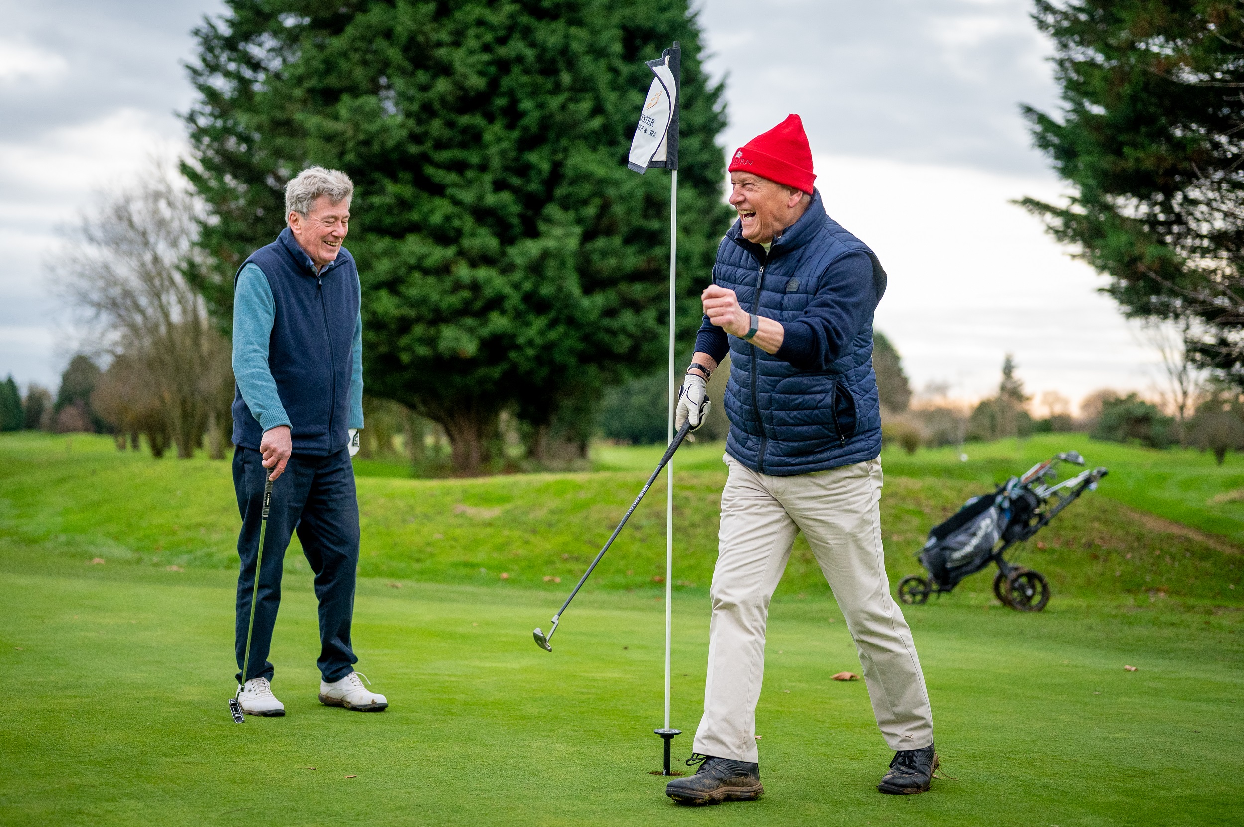 Two older men golfing and laughing