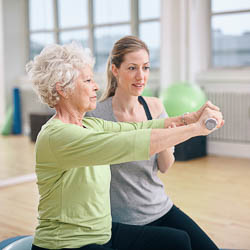 Older adult female with exercise coach